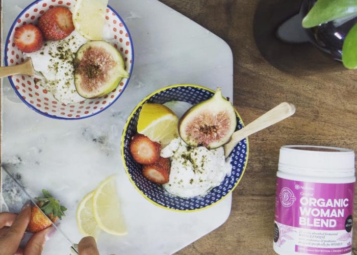 Our wholefood probiotic next to two delicious bowls of fresh fruit and yoghurt.